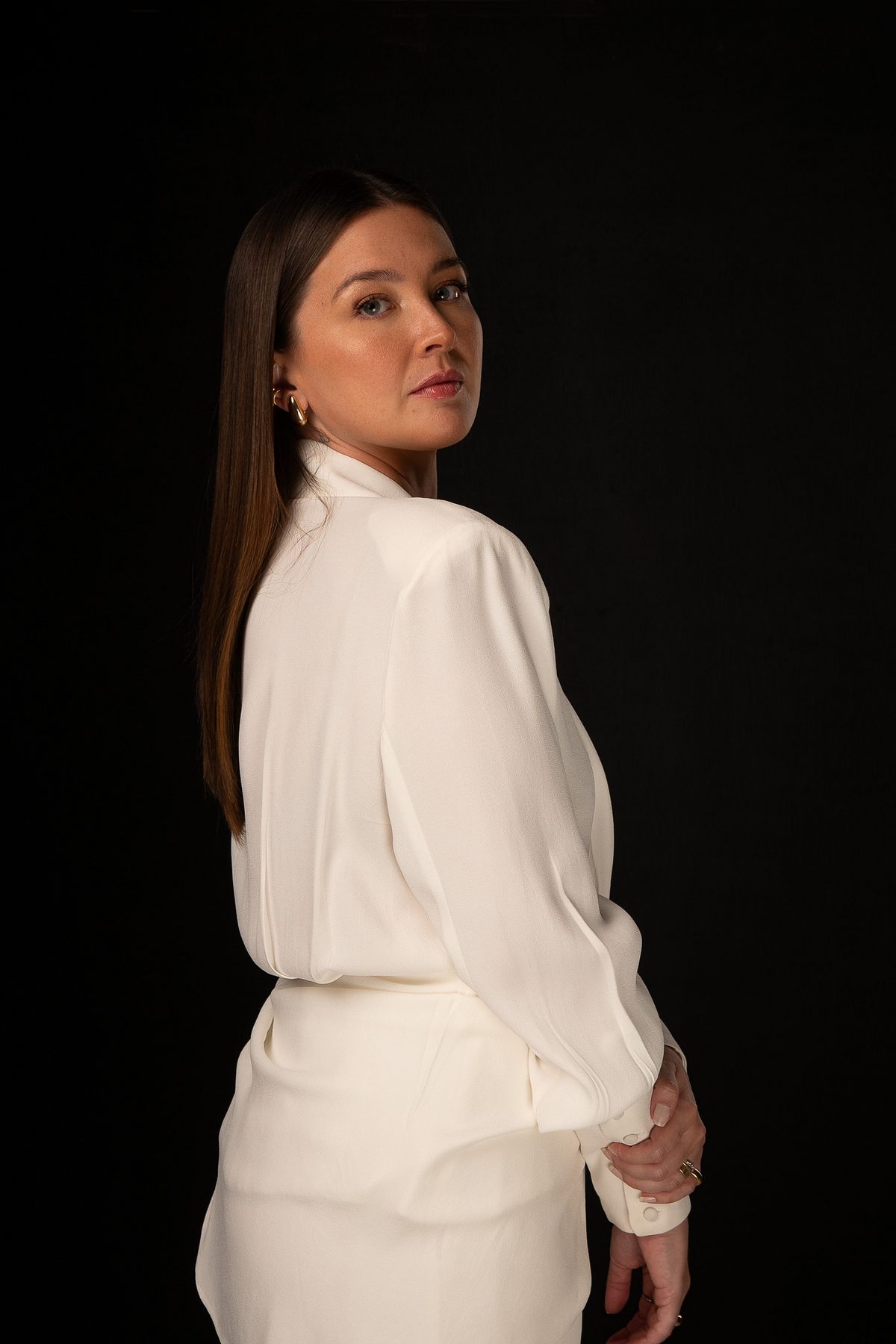 Mulher em conjunto branco, braços cruzados, retrato em preto e branco
